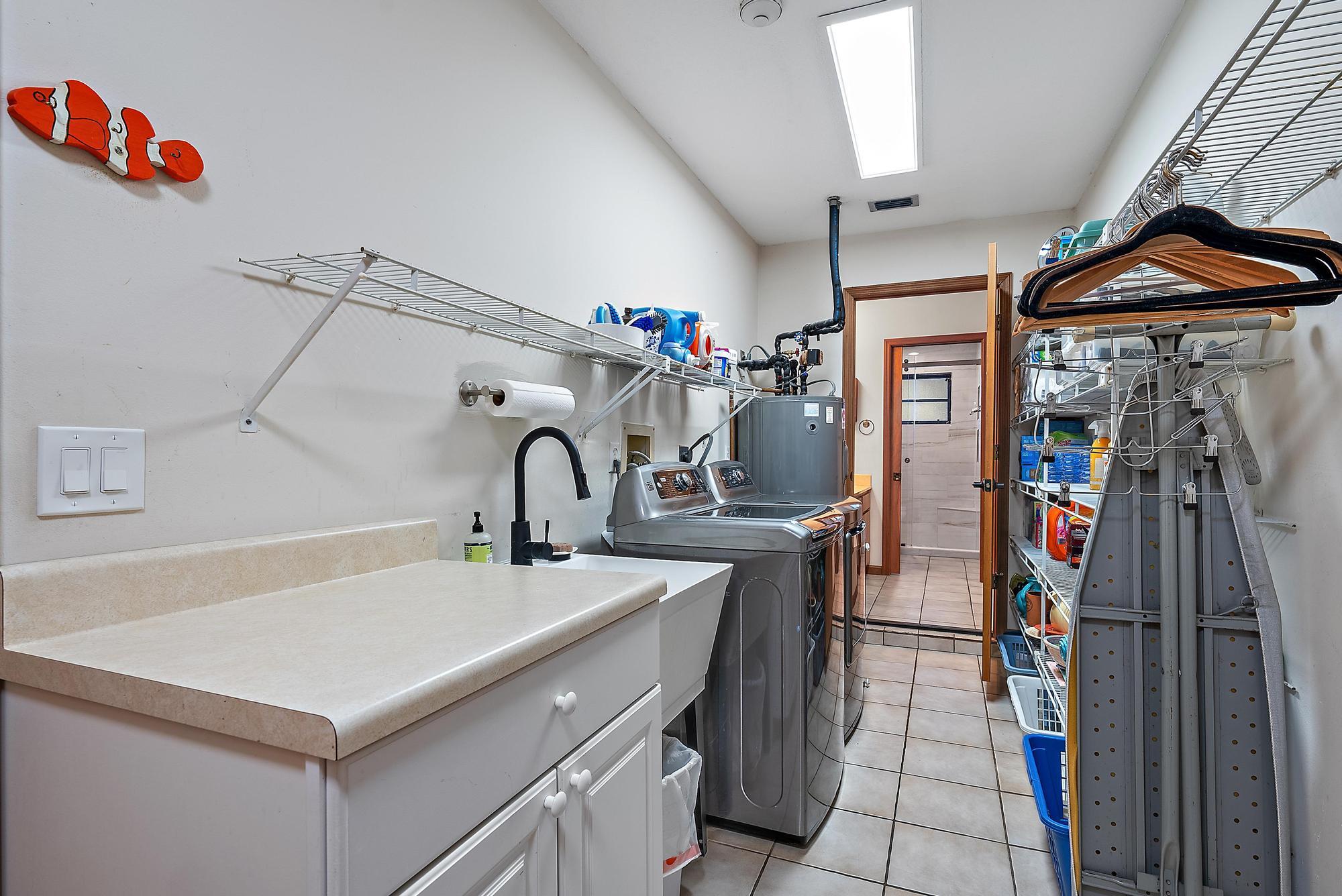 934 Penn Trail Jupiter, FL 33458 - Photo 44 of 54 a kitchen with a sink and a refrigerator