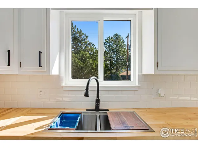 a kitchen with a sink and wooden floor