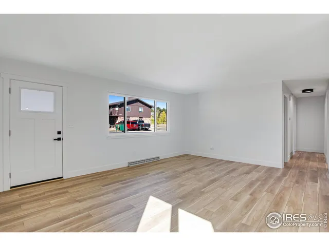 a view of an empty room and wooden floor