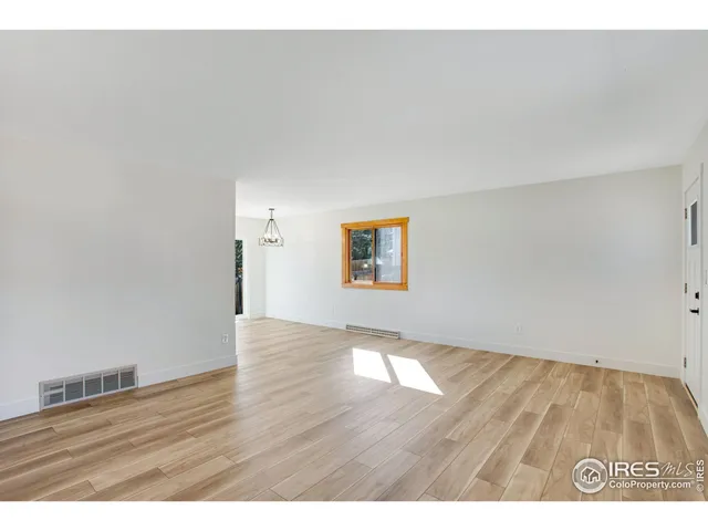 a view of an empty room and wooden floor
