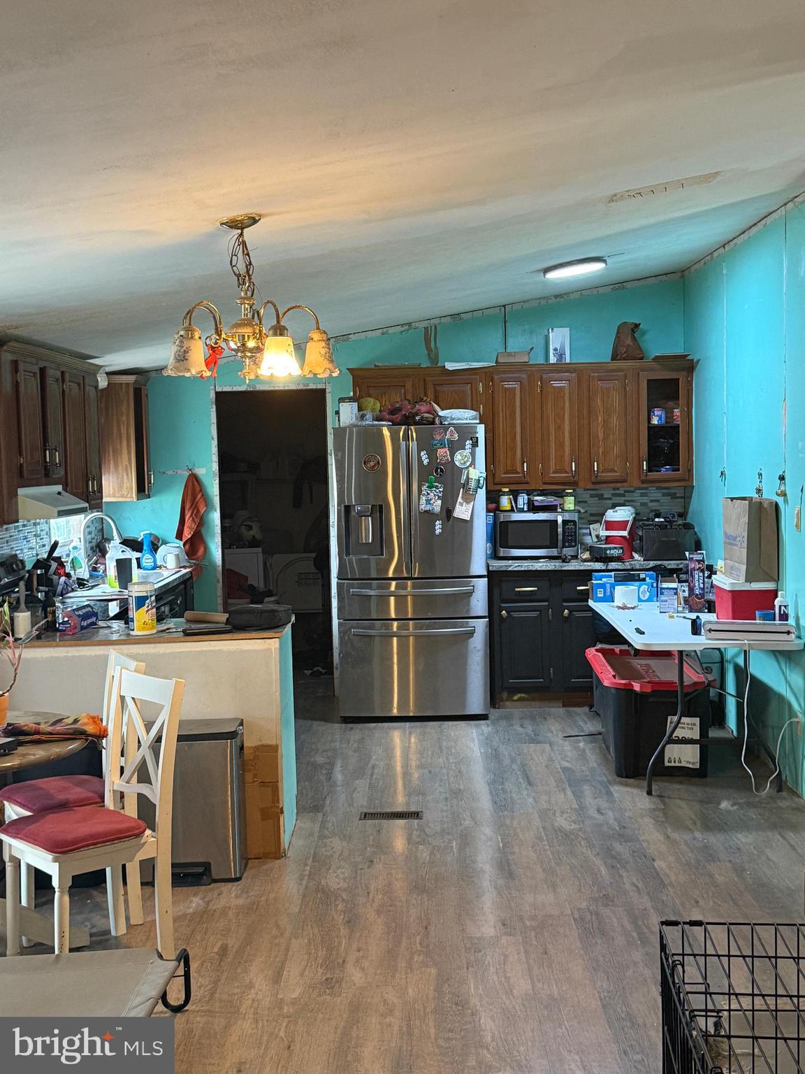 2418 Seeneytown Road Dover, DE 19904 - Photo 12 of 20 a kitchen with refrigerator and chairs