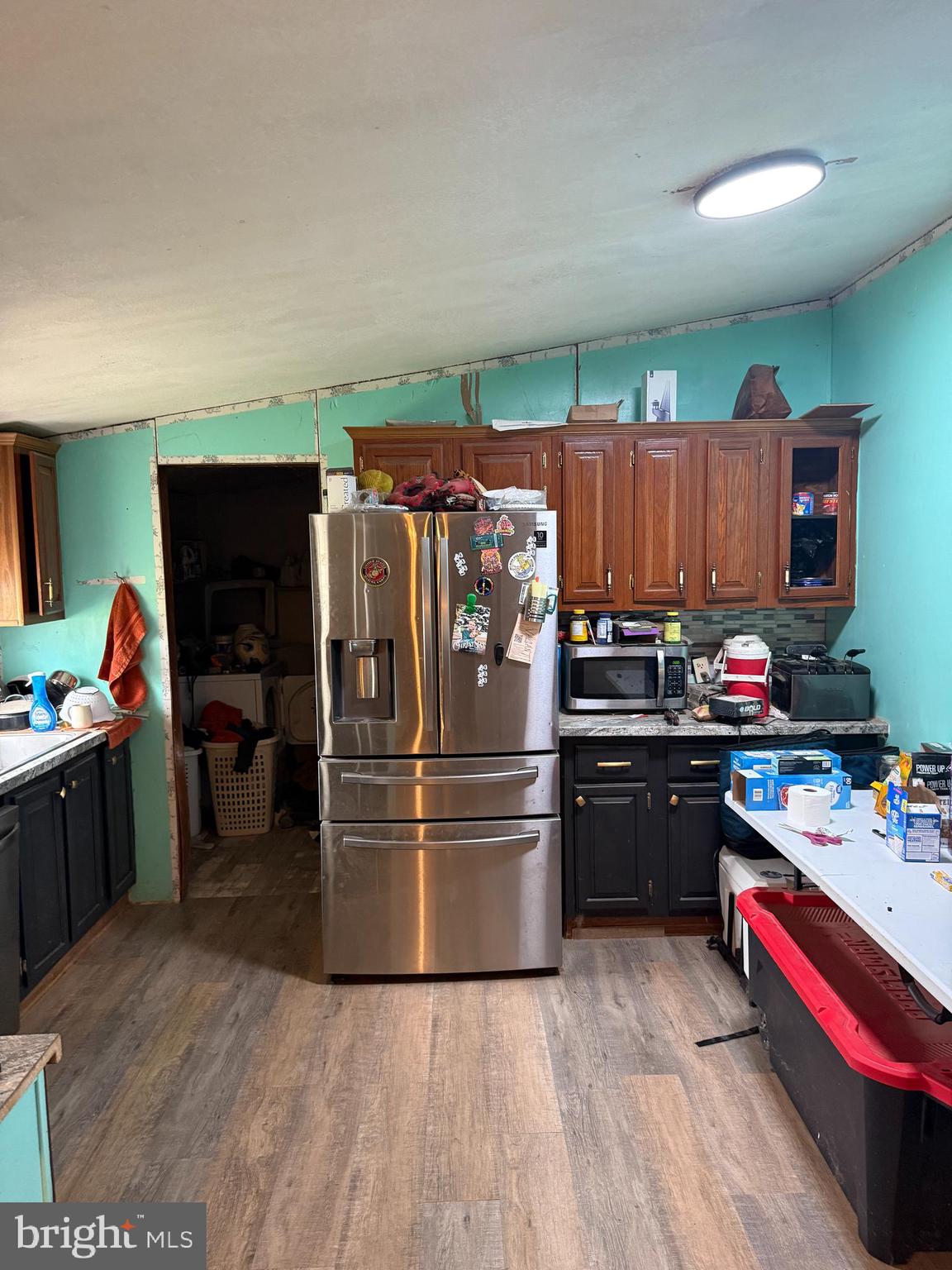 2418 Seeneytown Road Dover, DE 19904 - Photo 13 of 20 a kitchen with granite countertop a refrigerator stove and wooden floor