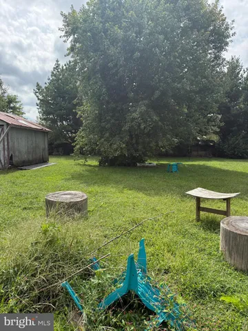 a view of a green yard with wooden fence