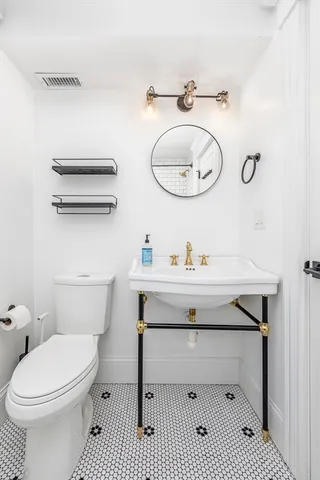 a bathroom with a sink a toilet and a mirror