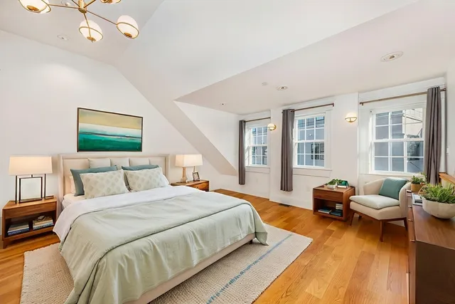 a spacious bedroom with a bed a couch and potted plant with the outer view