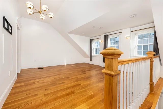 a view of a room with a chandelier and wooden floor