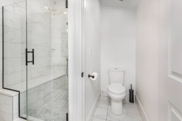 a bathroom with a toilet and a shower