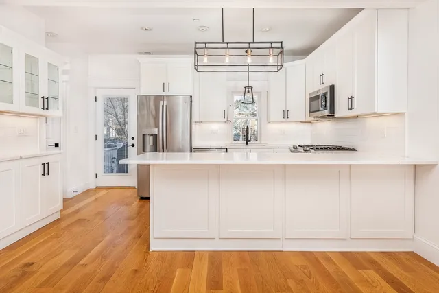 a kitchen with stainless steel appliances kitchen island granite countertop a refrigerator and microwave