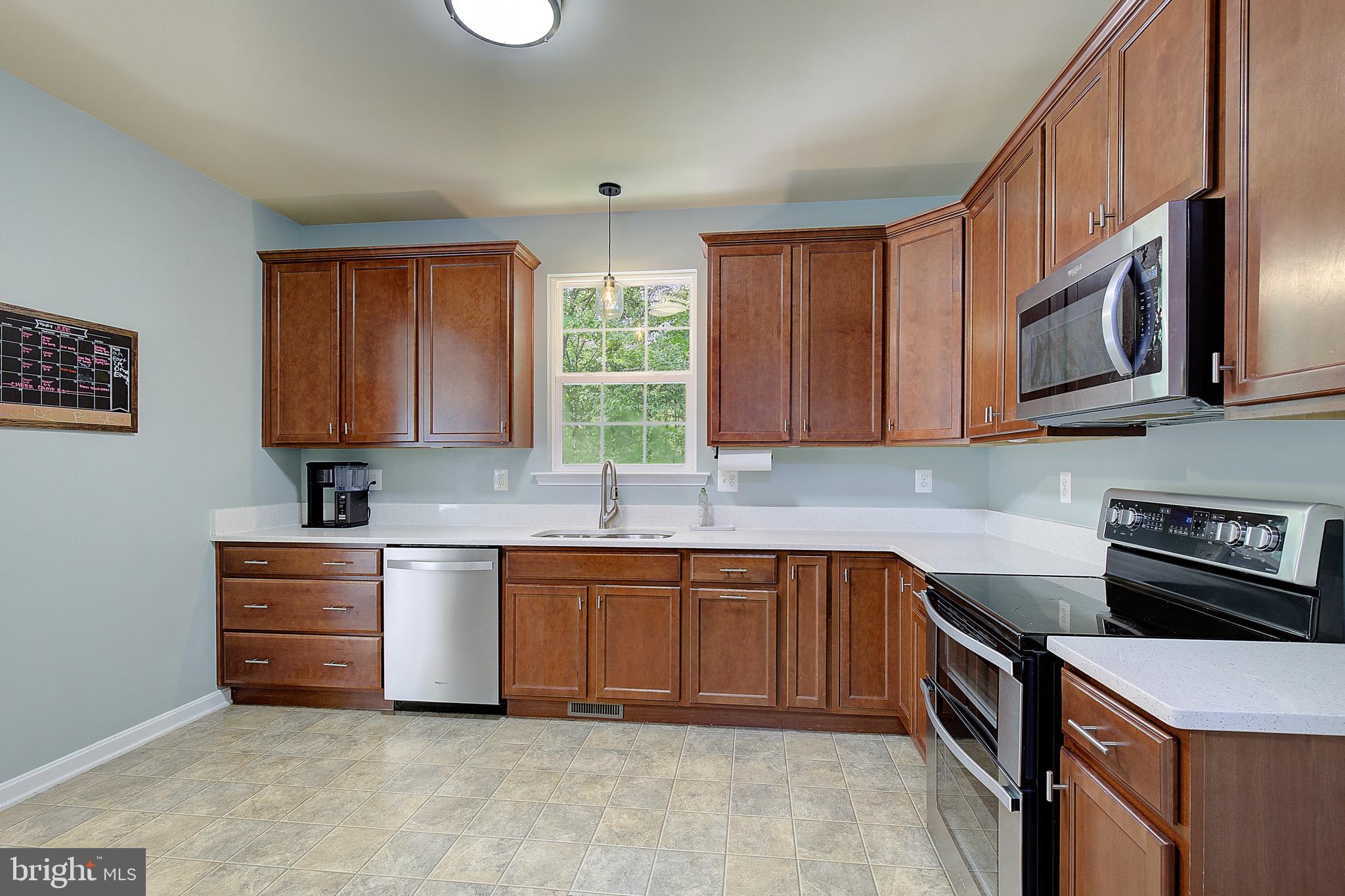 650 Stratton Place Prince Frederick, MD 20678 - Photo 16 of 51 a kitchen with stainless steel appliances granite countertop wooden cabinets a stove a sink and dishwasher