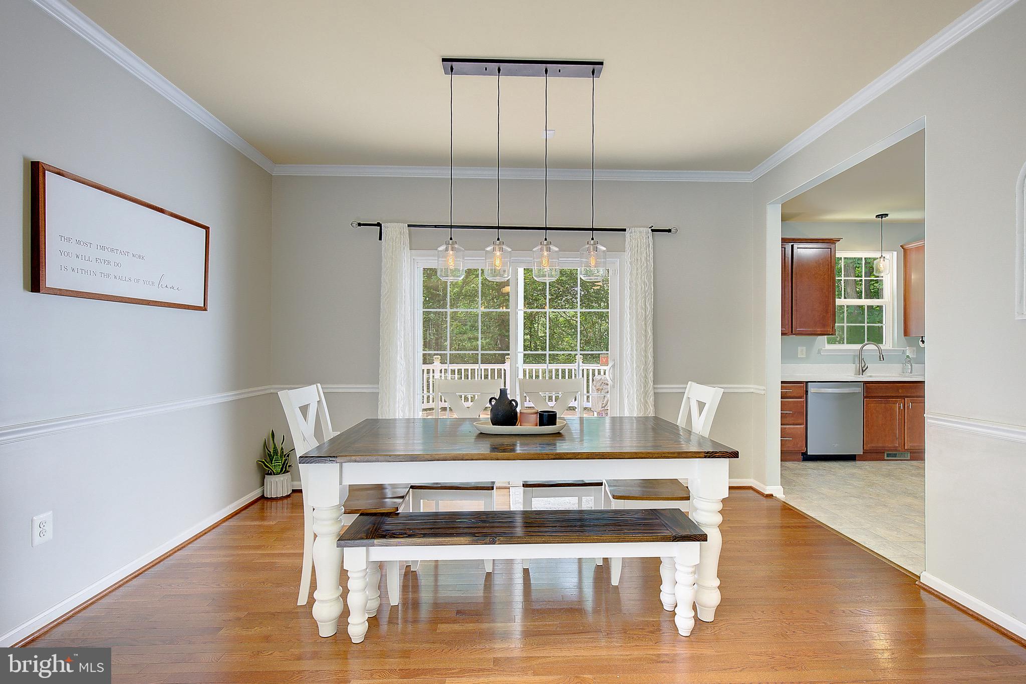 650 Stratton Place Prince Frederick, MD 20678 - Photo 10 of 51 a dining room with wooden floor and a floor to ceiling window