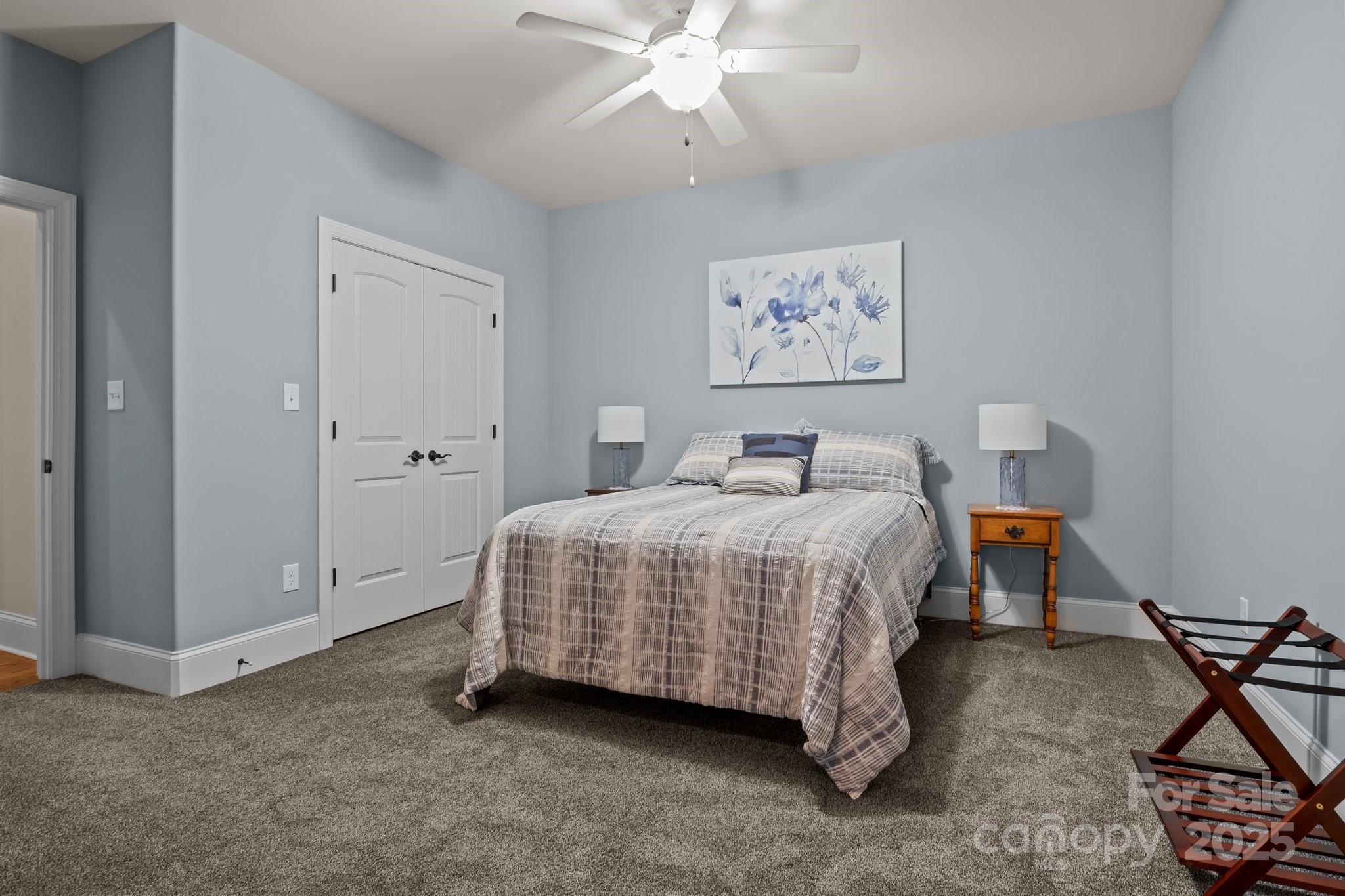 574 Barber Loop Mooresville, NC 28117 - Photo 19 of 34 a spacious bedroom with a bed and a chandelier