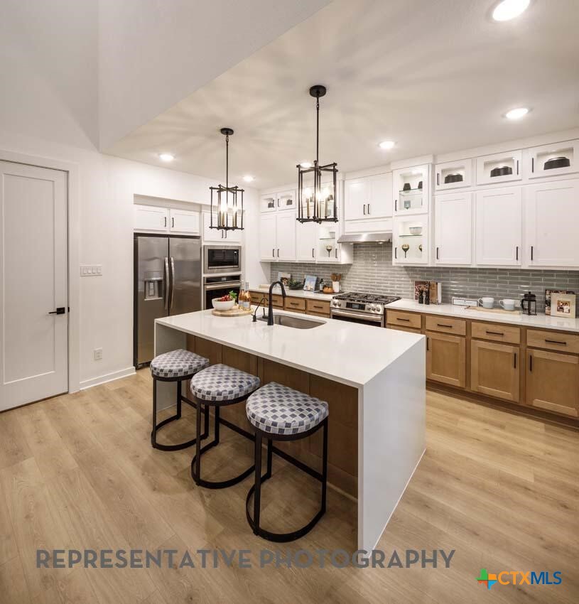 8808 Fallkill Drive Austin, TX 78744 - Photo 4 of 34 a kitchen with a sink a stove and chairs