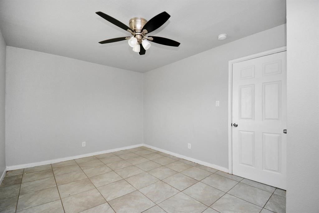 8127 Colonial Lane, Unit 2 Houston, TX 77051 - Photo 4 of 11 an empty room with a ceiling fan and window