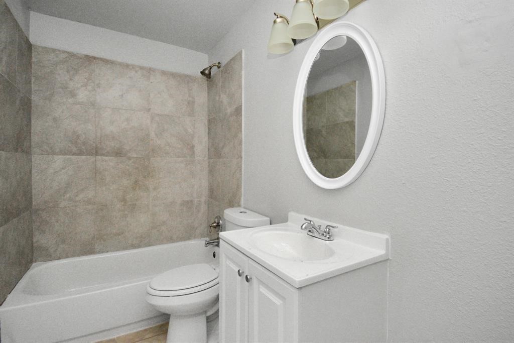 8127 Colonial Lane, Unit 2 Houston, TX 77051 - Photo 10 of 11 a bathroom with a sink a toilet and a mirror