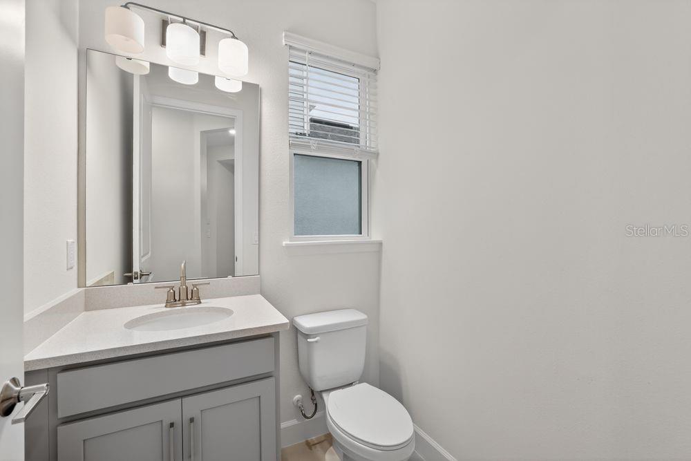13505 Commons Avenue Parrish, FL 34219 - Photo 21 of 40 a bathroom with a toilet sink vanity and mirror