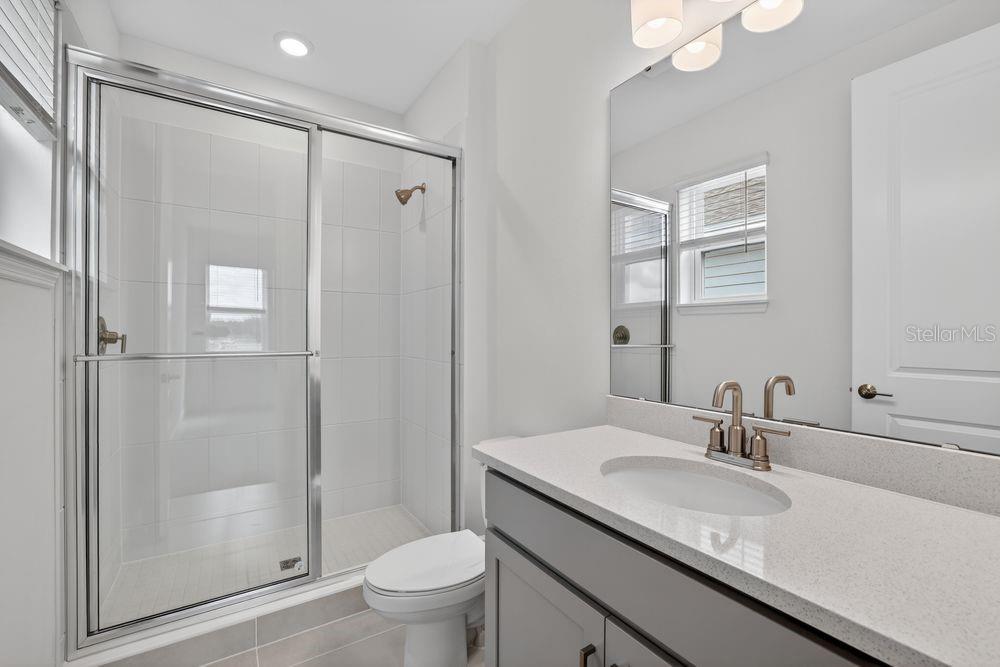 13505 Commons Avenue Parrish, FL 34219 - Photo 23 of 40 a bathroom with a granite countertop sink toilet and shower