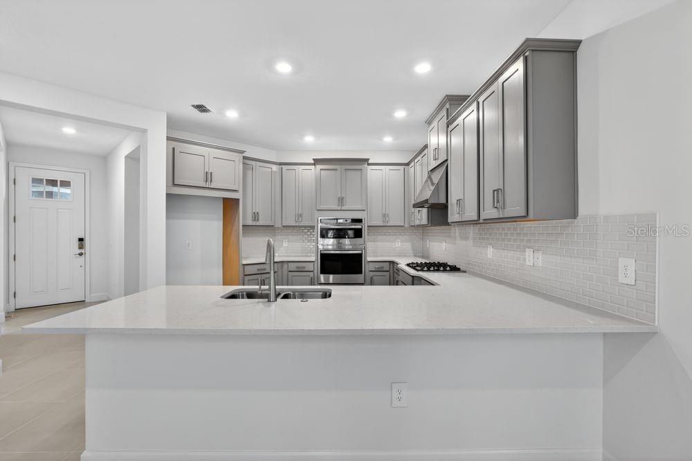 13505 Commons Avenue Parrish, FL 34219 - Photo 3 of 40 a kitchen with stainless steel appliances a refrigerator sink and microwave