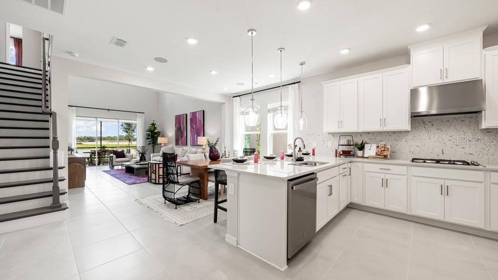 13505 Commons Avenue Parrish, FL 34219 - Photo 5 of 26 a kitchen that has a lot of cabinets a sink and a stove in it