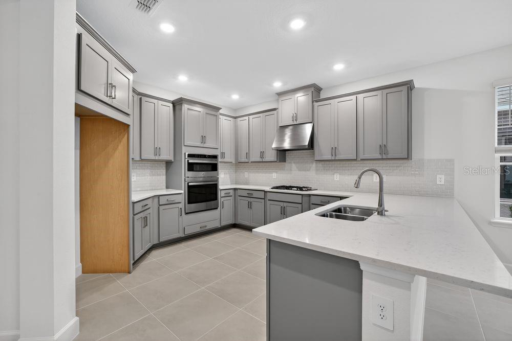 13505 Commons Avenue Parrish, FL 34219 - Photo 5 of 40 a kitchen with a sink stainless steel appliances and white cabinets