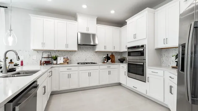 a kitchen with white cabinets and stainless steel appliances