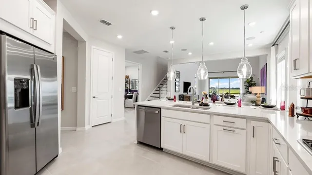 a kitchen with a sink a stove and chairs