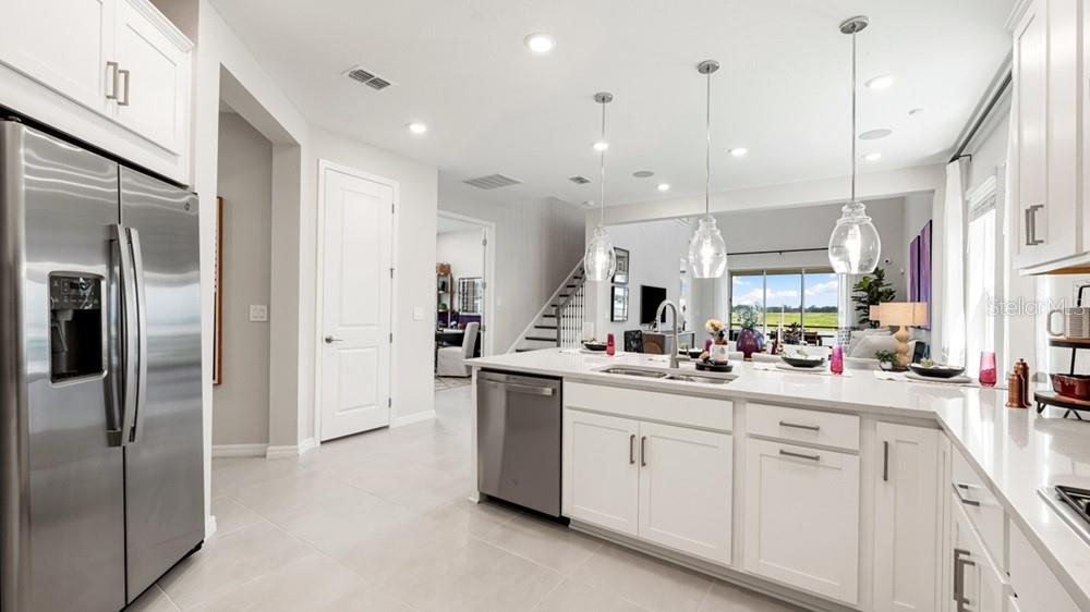 13505 Commons Avenue Parrish, FL 34219 - Photo 8 of 26 a kitchen with white cabinets and stainless steel appliances