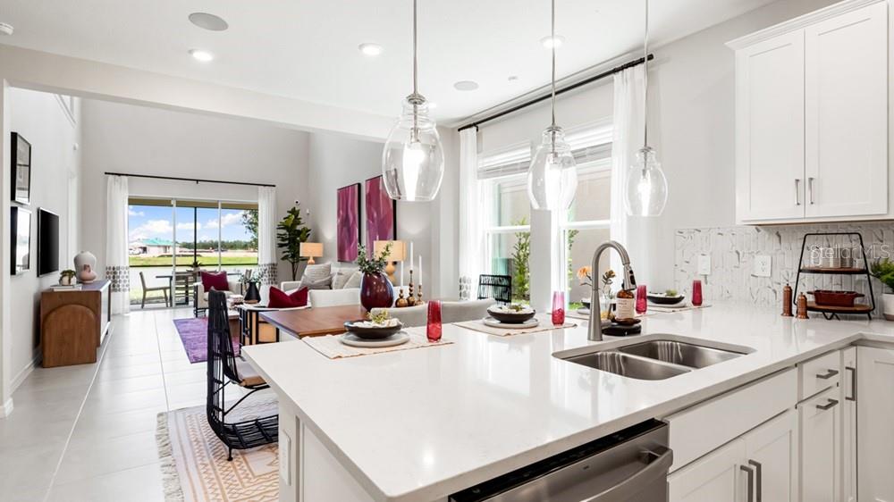 13505 Commons Avenue Parrish, FL 34219 - Photo 9 of 26 a kitchen with a sink a stove and chairs