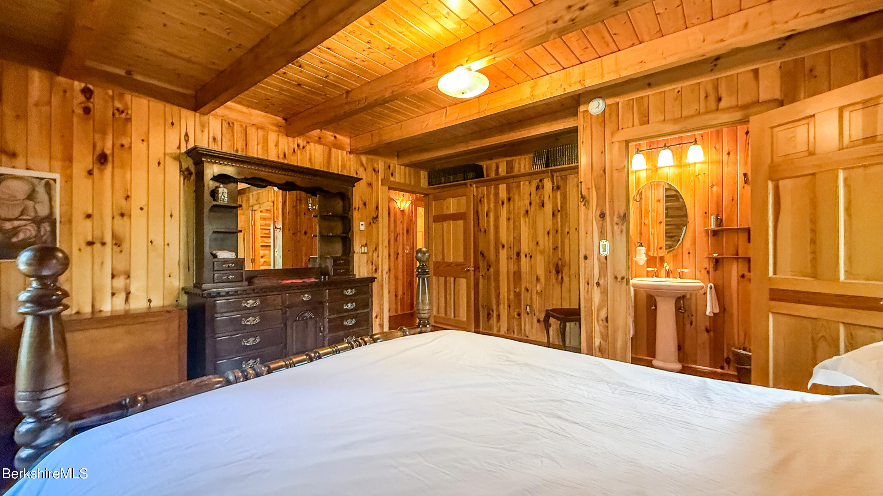 233 Algerie Road Becket, MA 01223 - Photo 20 of 48 a bedroom with a bed and wooden cabinets