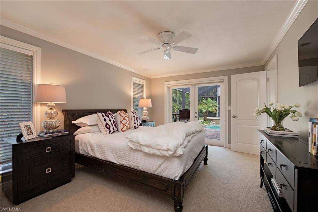691 Ketch Drive Naples, FL 34103 - Photo 11 of 16 a bedroom with a large bed and a chandelier