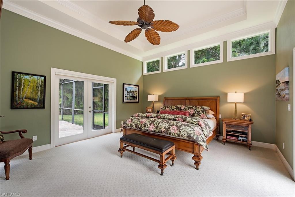 691 Ketch Drive Naples, FL 34103 - Photo 9 of 16 a bedroom with a bed and a chandelier fan