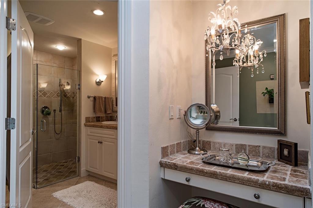 691 Ketch Drive Naples, FL 34103 - Photo 10 of 16 a bathroom with a granite countertop shower a sink and a mirror