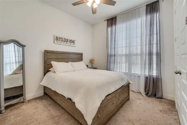 a bed sitting in a bedroom next to a window and a chandelier