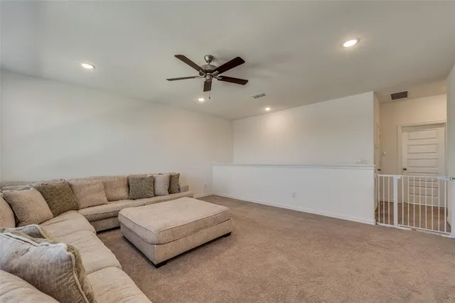 a living room with furniture and a ceiling fan