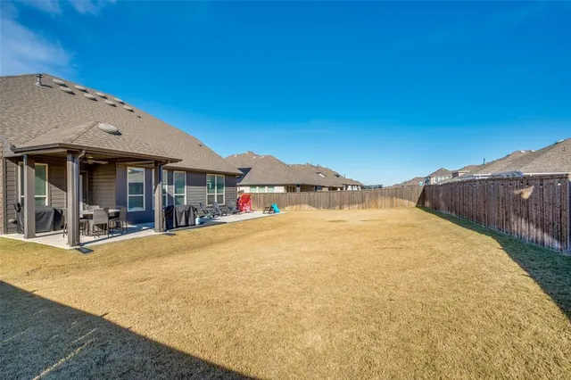 a small pool with lawn chairs under an umbrella