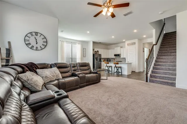 a living room with furniture and a view of kitchen