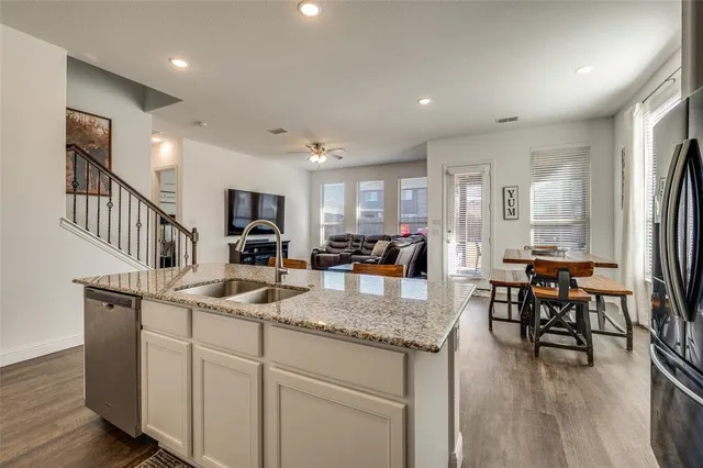 a kitchen with sink refrigerator dining table and chairs