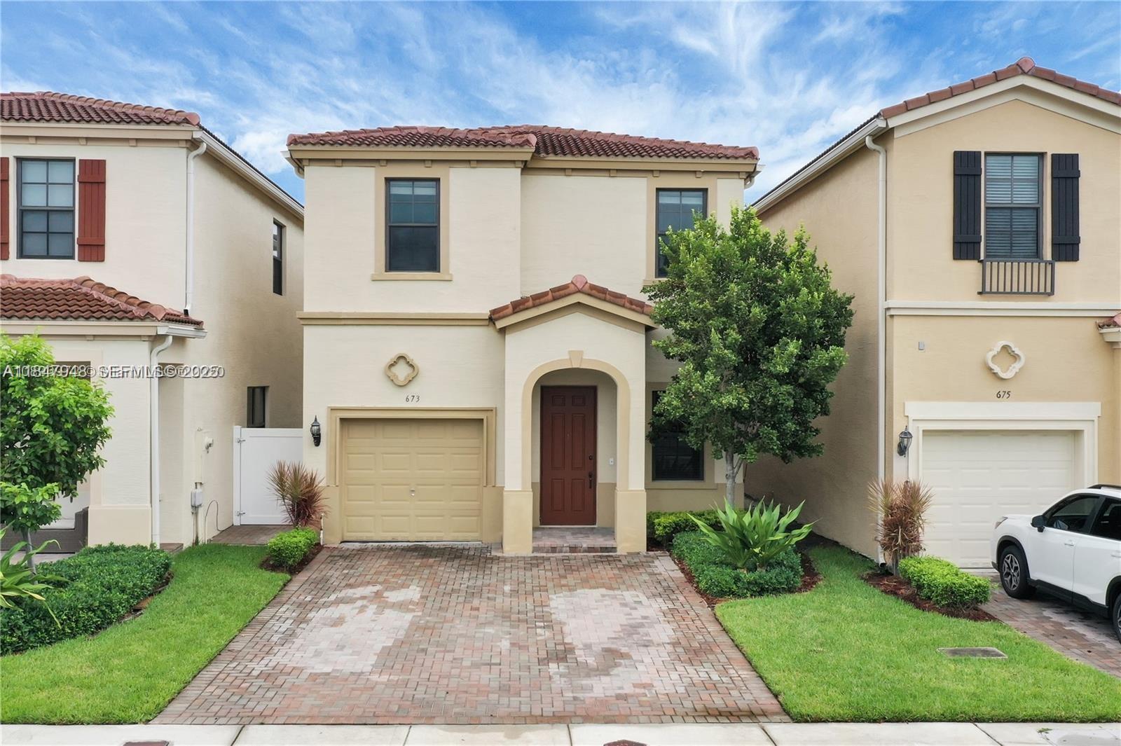 a front view of a house with a yard and garage