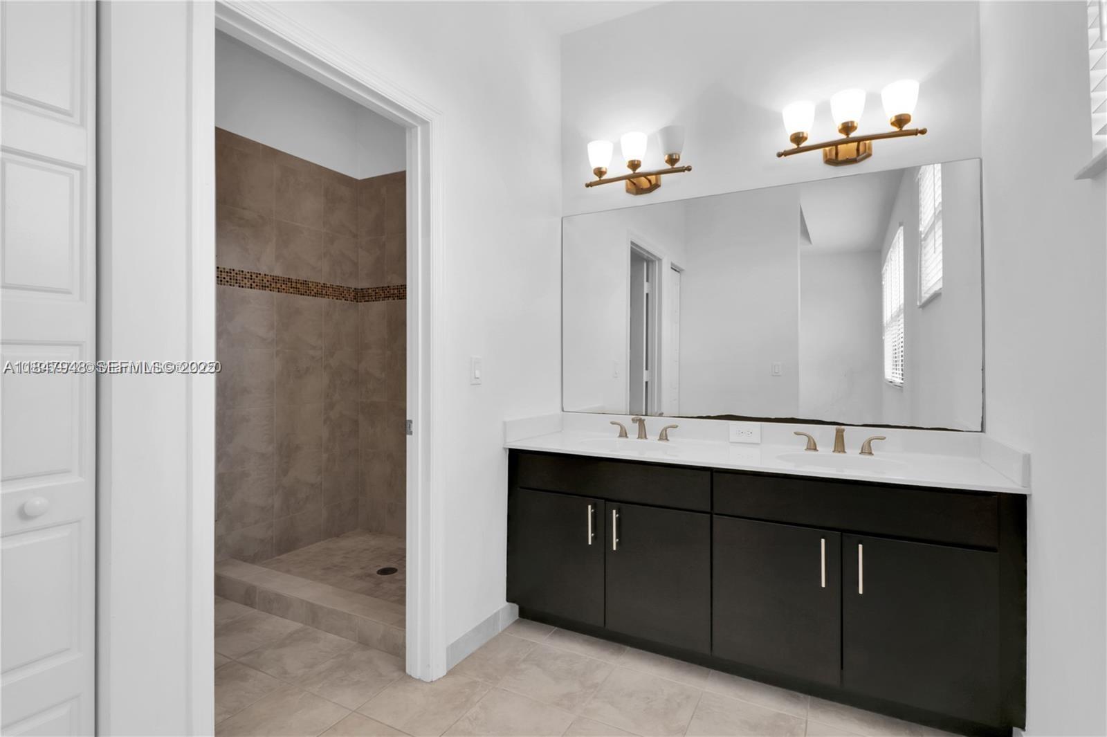 673 Northeast 191st Street Miami, FL 33179 - Photo 18 of 25 a bathroom with a sink and a mirror