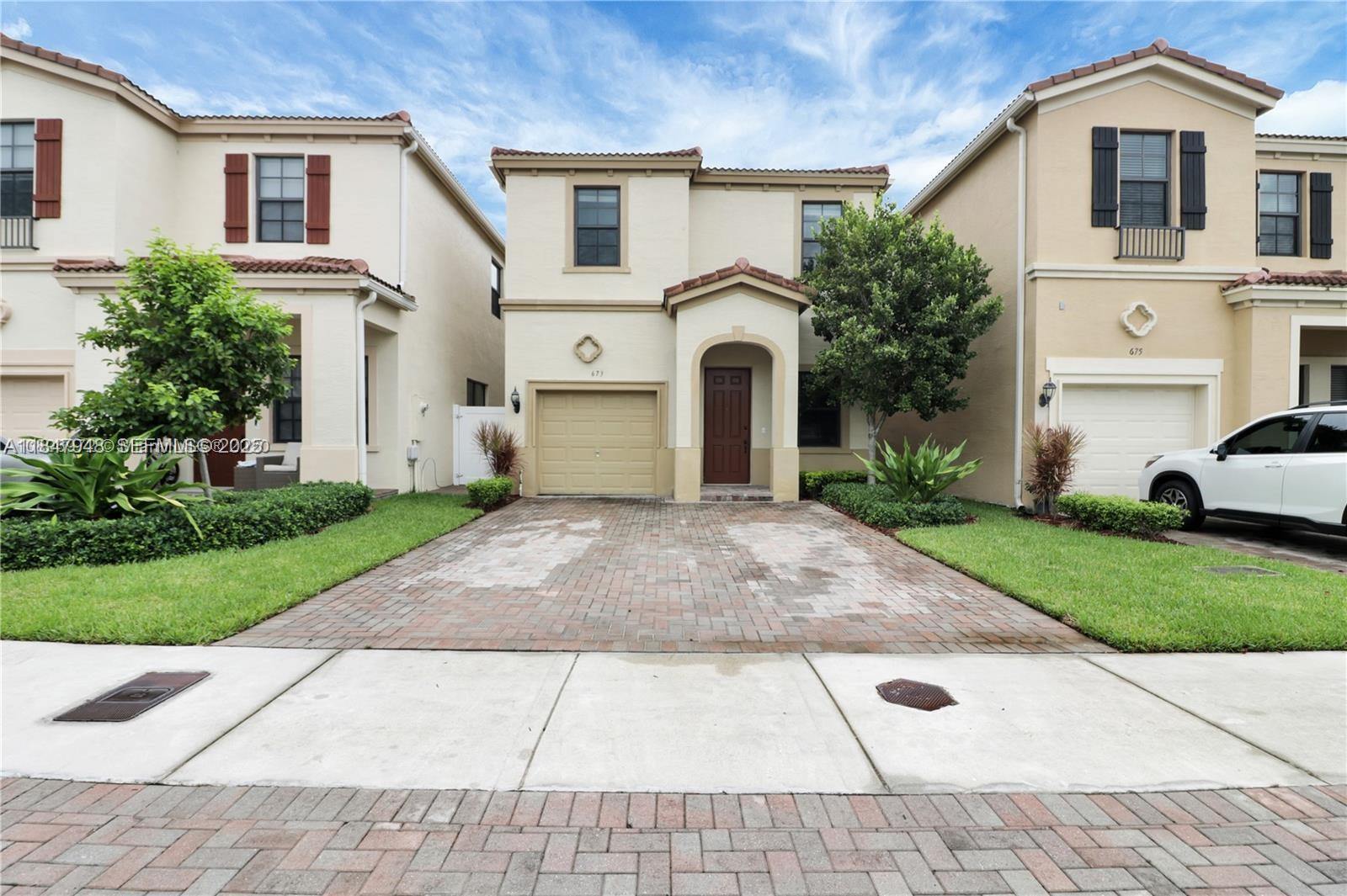 673 Northeast 191st Street Miami, FL 33179 - Photo 2 of 25 a view of a white house with a yard and plants
