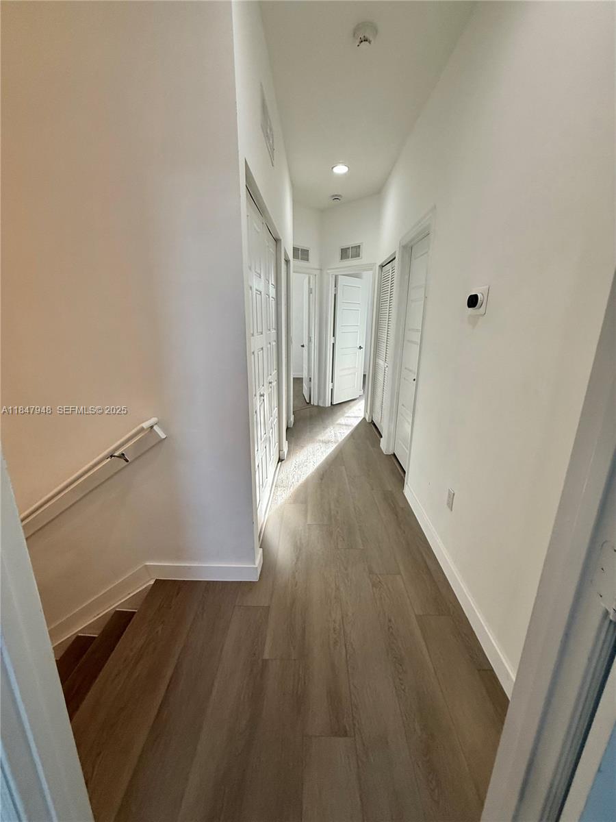 673 Northeast 191st Street Miami, FL 33179 - Photo 21 of 25 a view of a hallway with wooden floor