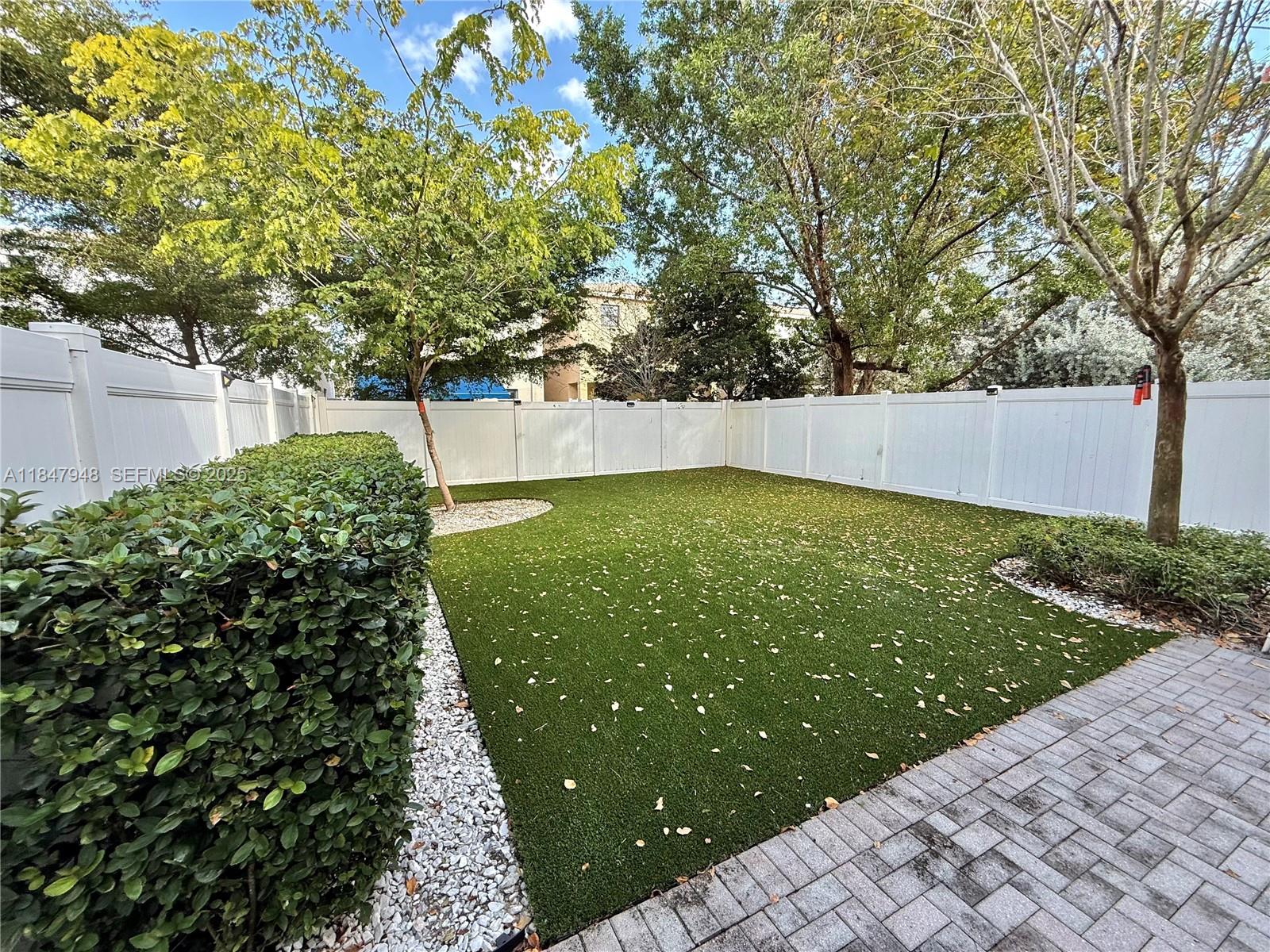 673 Northeast 191st Street Miami, FL 33179 - Photo 23 of 25 a view of a garden with a bench