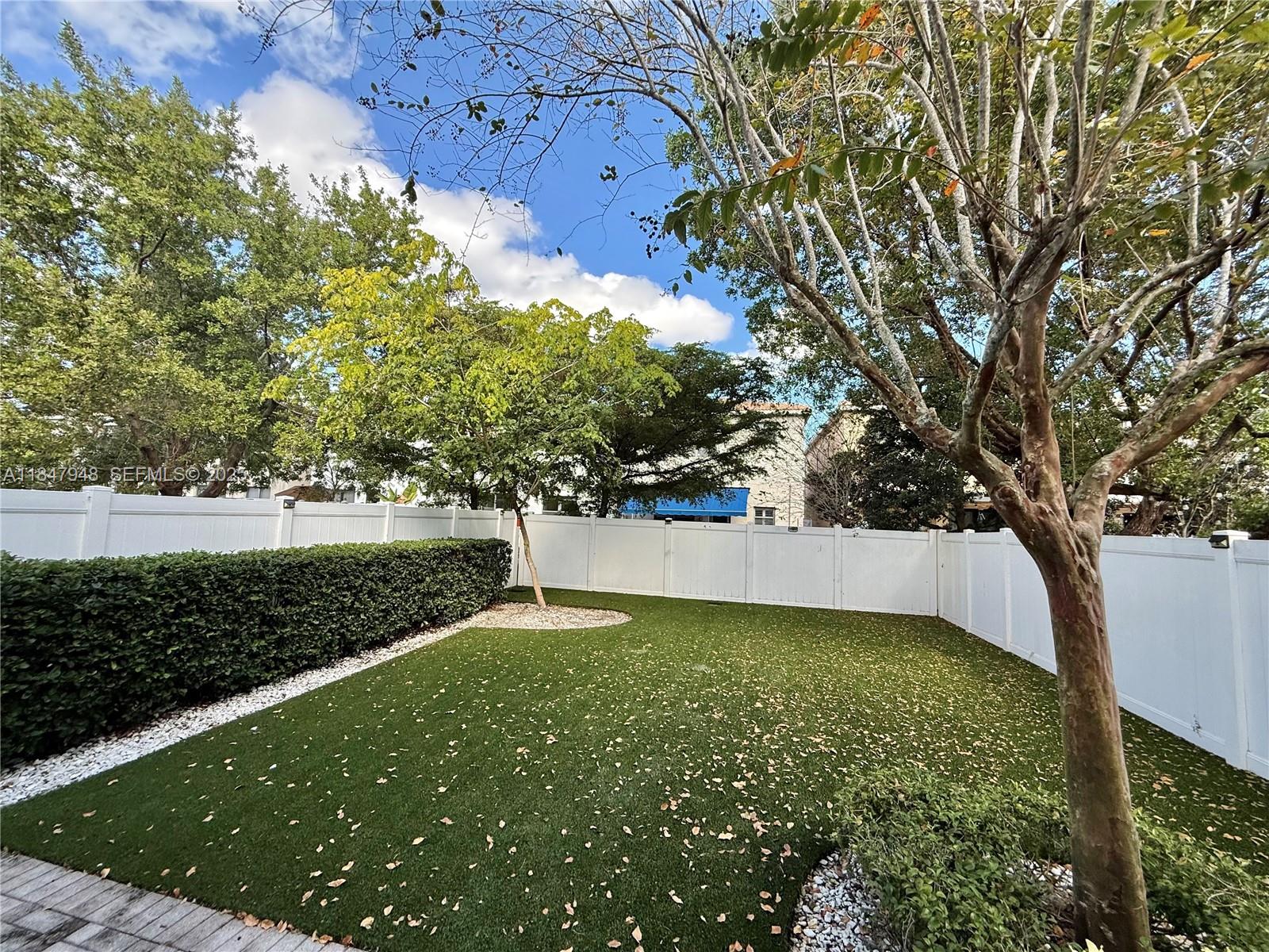 673 Northeast 191st Street Miami, FL 33179 - Photo 25 of 25 a view of a yard with large trees