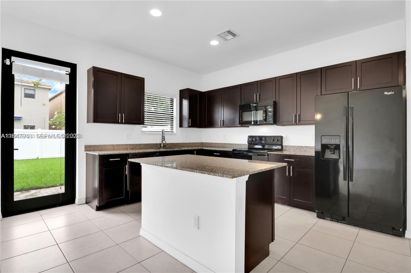 673 Northeast 191st Street Miami, FL 33179 - Photo 6 of 25 a kitchen with stainless steel appliances granite countertop a refrigerator and a stove