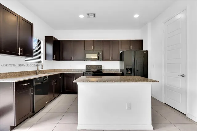 a kitchen with a sink a stove top oven and refrigerator