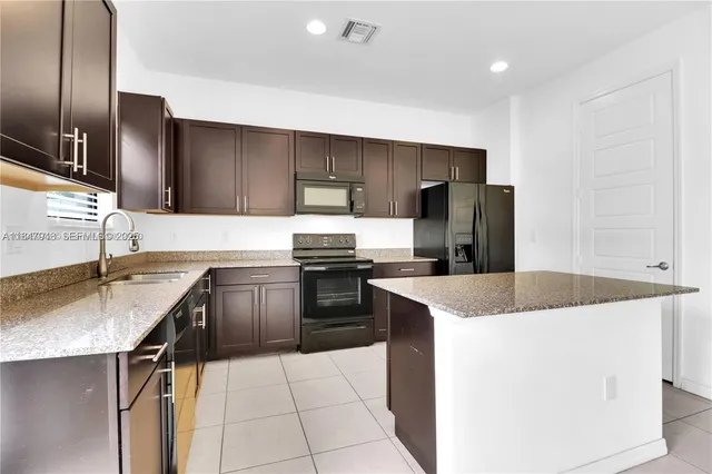 a view of kitchen with stainless steel appliances granite countertop a refrigerator a sink dishwasher and a stove