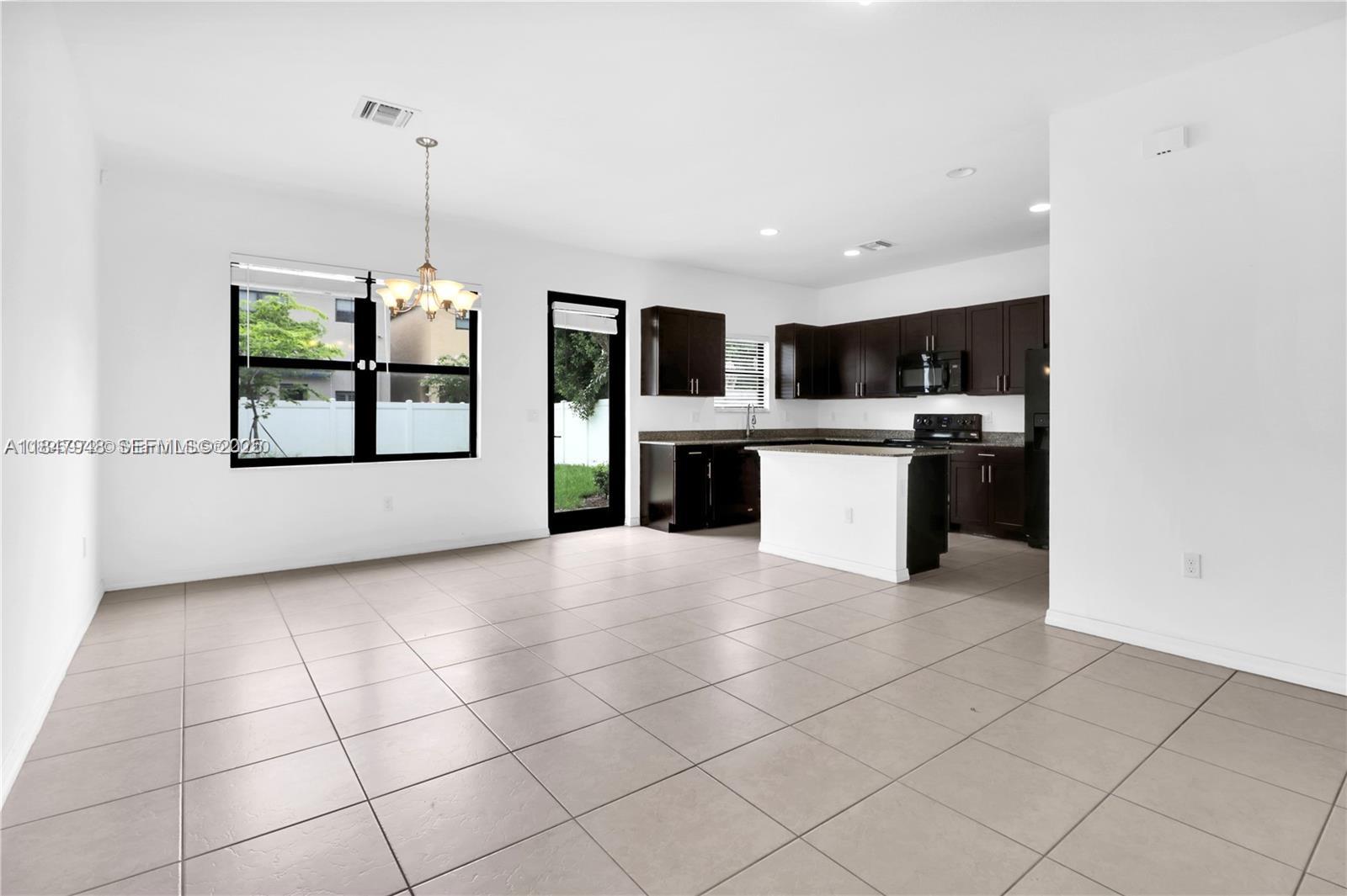 673 Northeast 191st Street Miami, FL 33179 - Photo 10 of 25 a view of a kitchen with microwave and windows