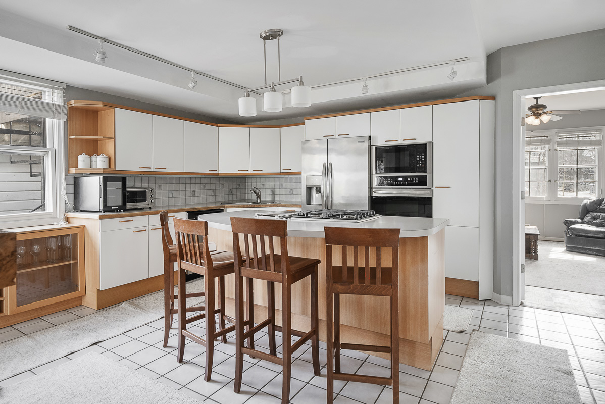515 Maple Avenue Wilmette, IL 60091 - Photo 6 of 24 a kitchen with stainless steel appliances kitchen island granite countertop a dining table chairs and a refrigerator