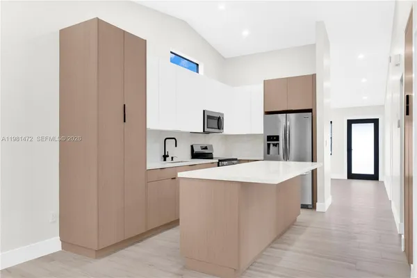 a kitchen with stainless steel appliances a refrigerator sink and microwave