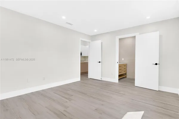a view of an empty room with wooden floor