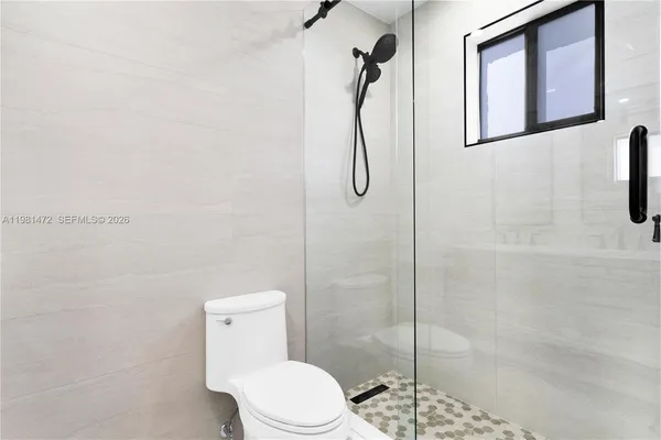 a white toilet sitting next to a bathroom shower
